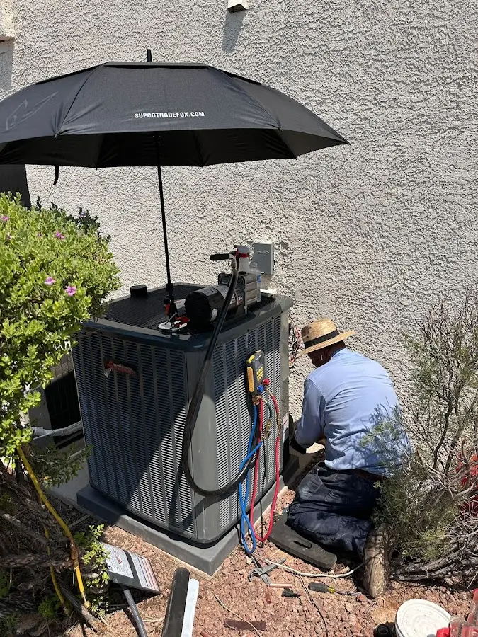 HVAC technician performing outdoor AC maintenance in Kent